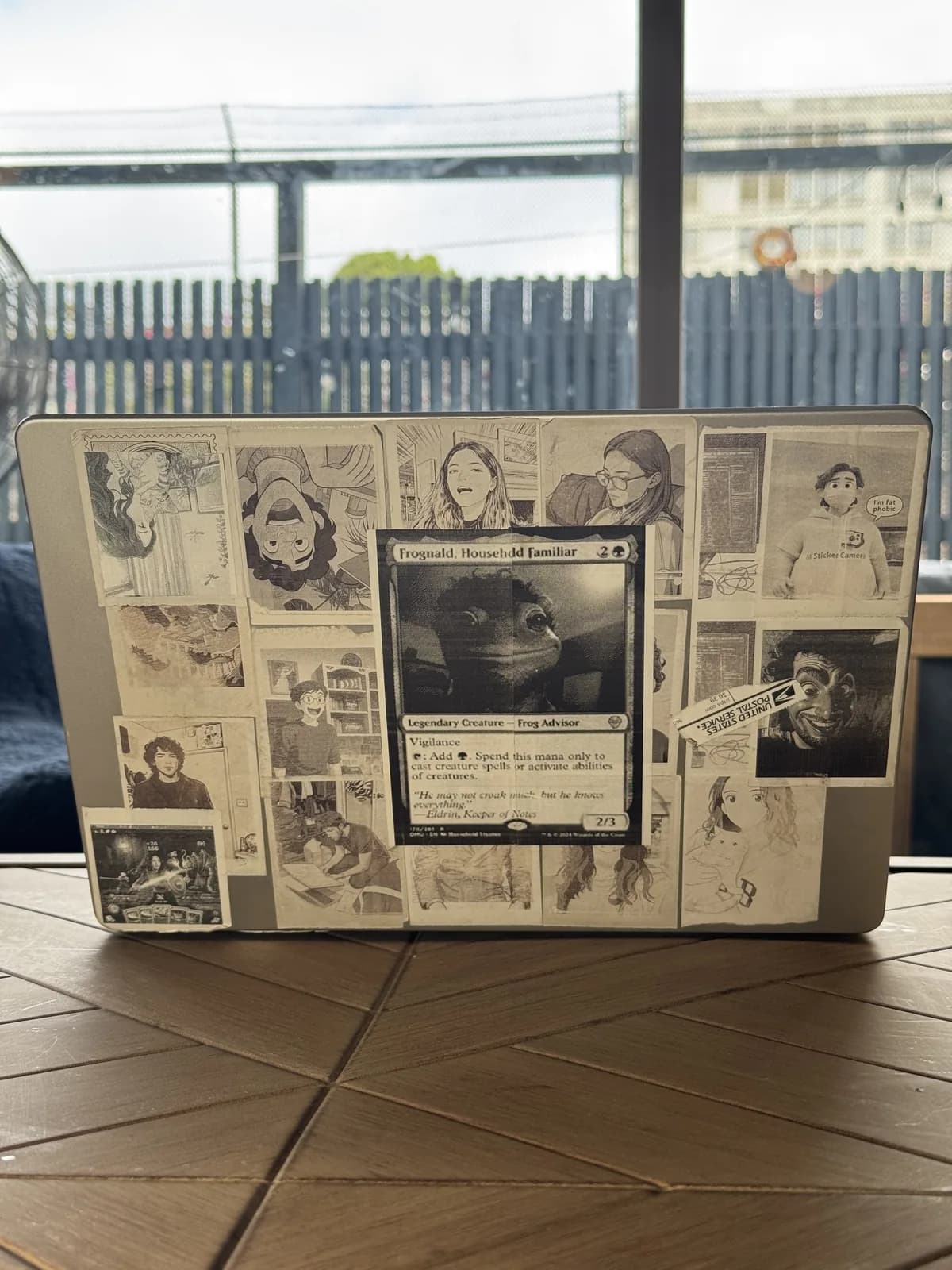 Laptop covered with a collage of black-and-white Sticker Camera prints