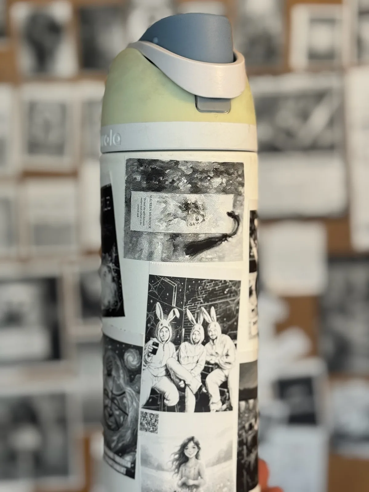 Water bottle covered with black-and-white photo stickers